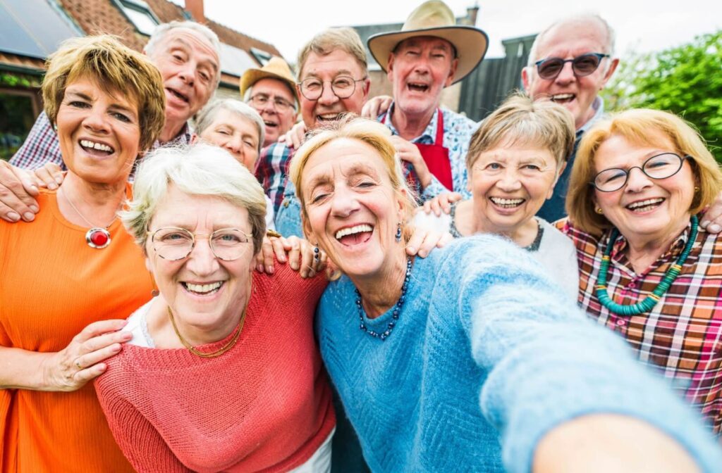  a group of seniors, who are friends, smile for a group photo.