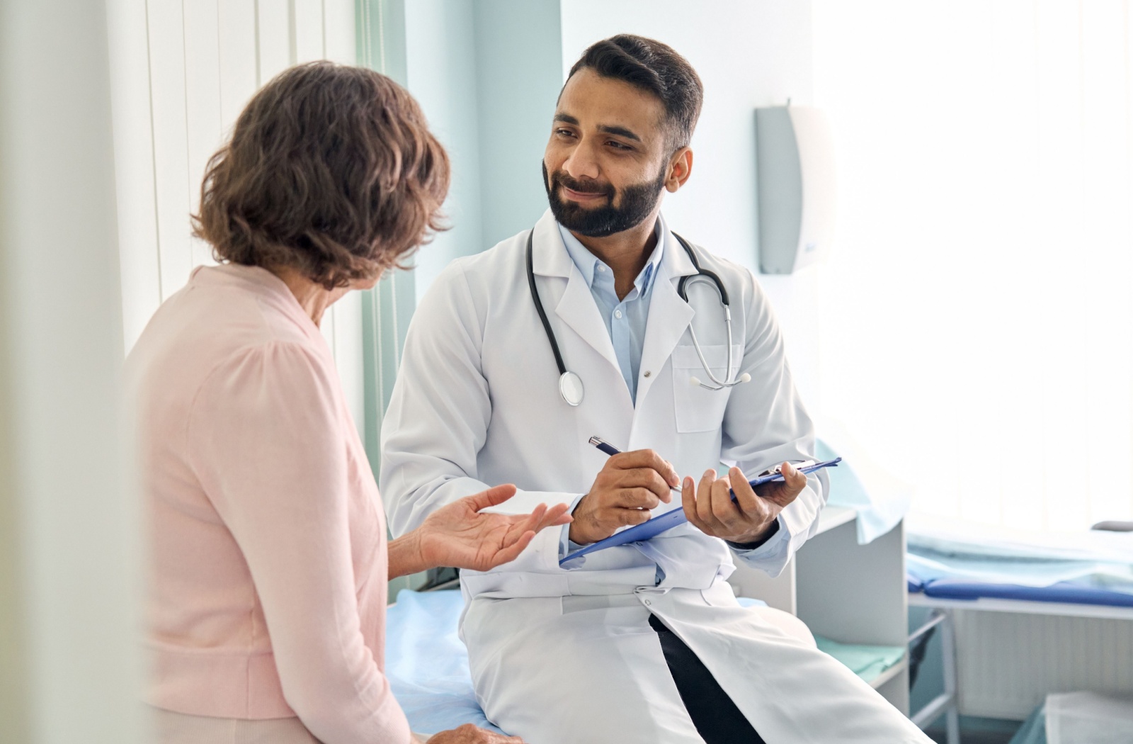 A senior woman talks with her family doctor about her general health.