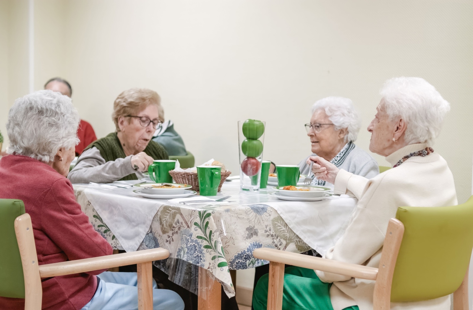 Seniors seated at a table dining together.