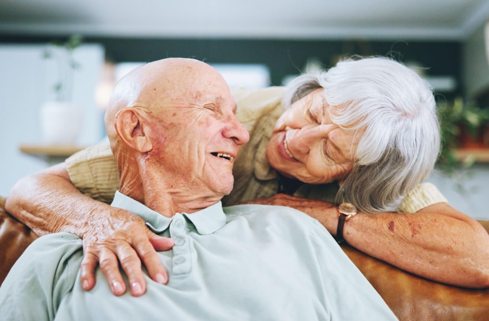 A happy, mature couple embracing each other in assisted living.