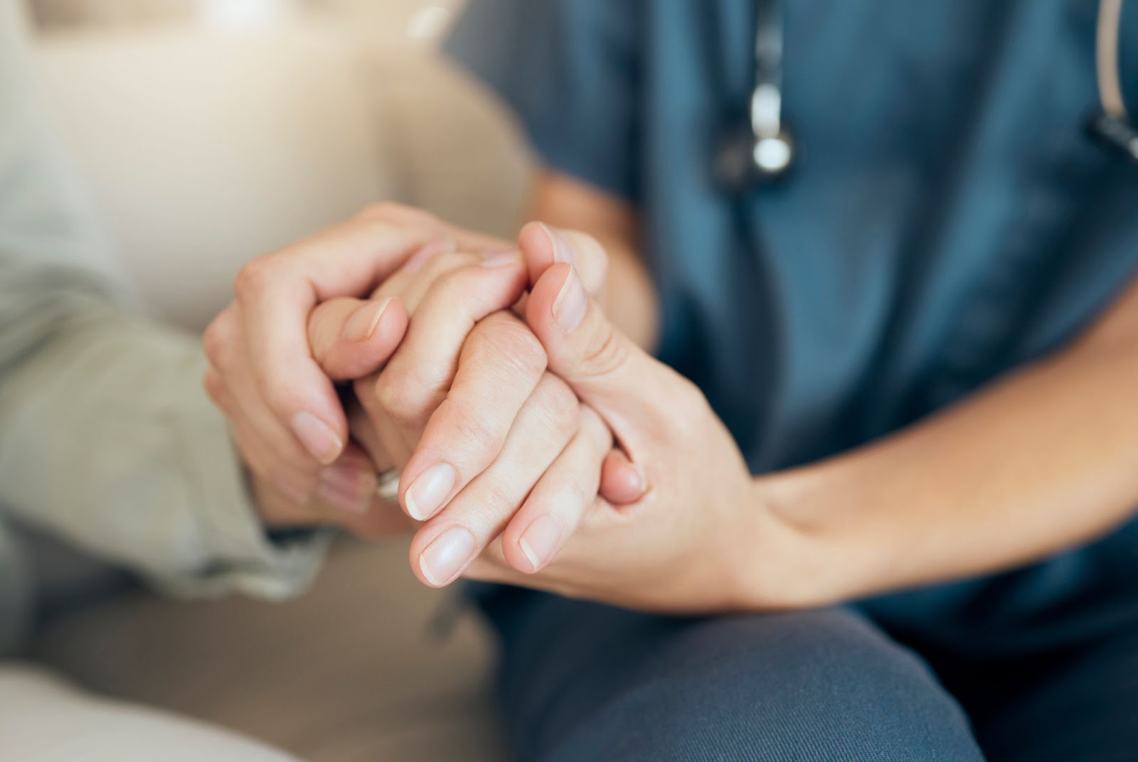 A senior parents and their child holding hands to show care as they visited their parent in assisted living.