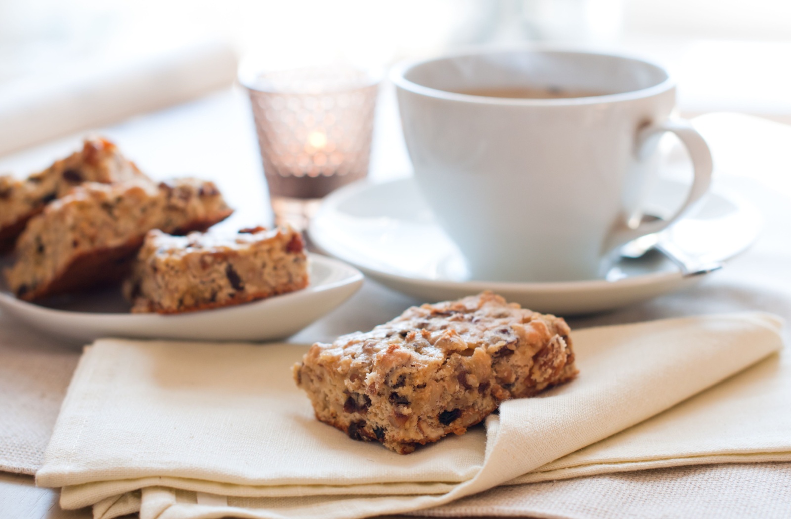 Close-up of a cup of tea and a plate of baked goods.