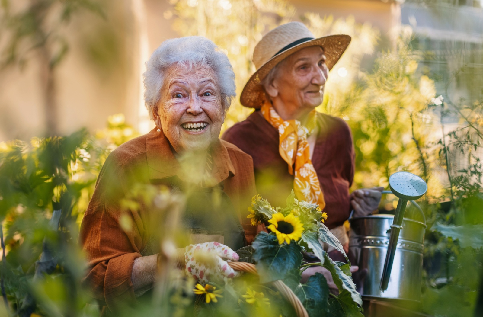 Two senior friends participate in gardening activities within their senior living community.